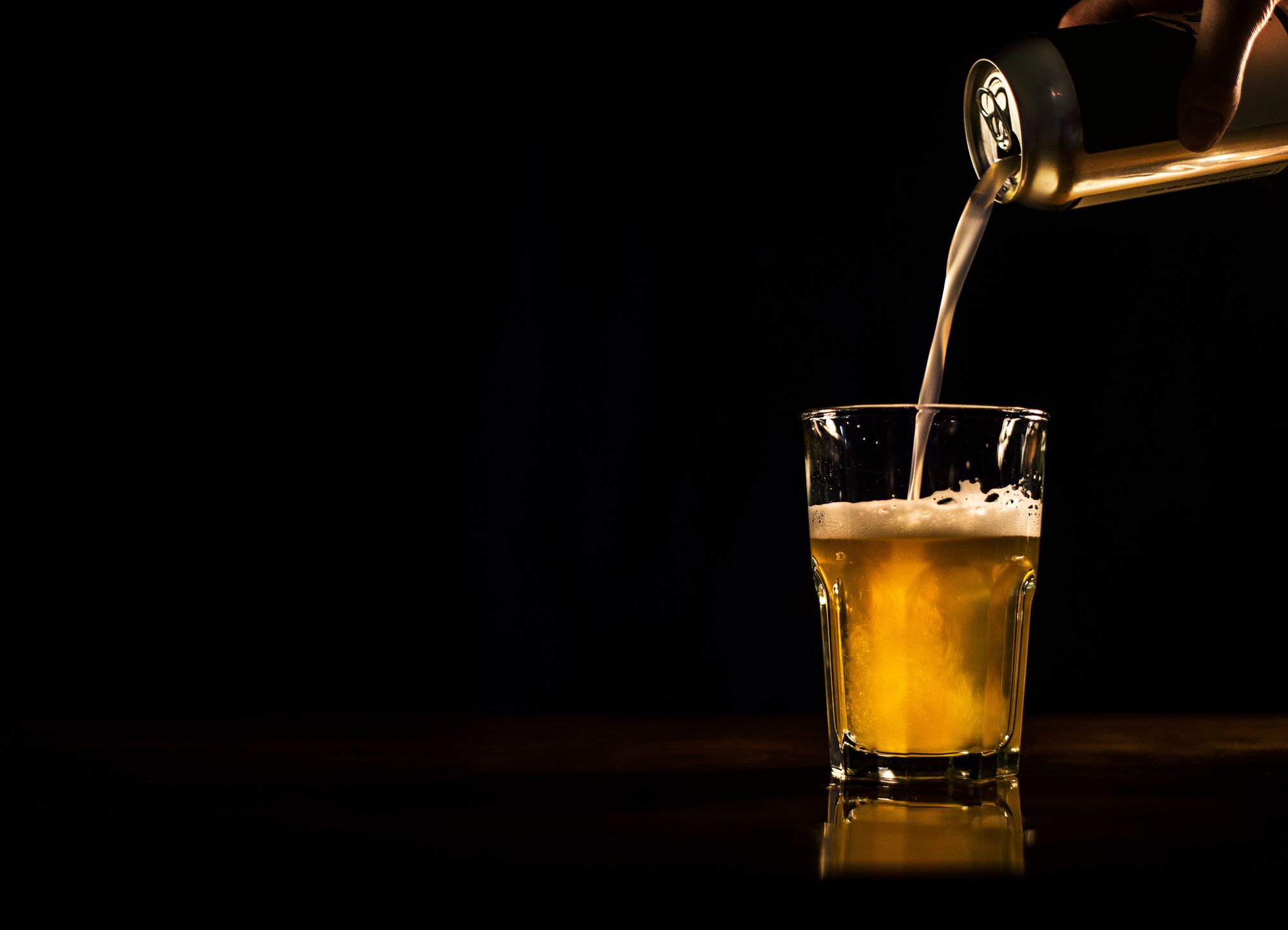 Beer being poured from can into glass